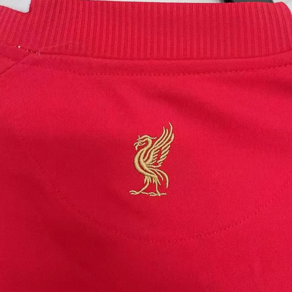 Liverpool hemmatröja retro röd 2008/10, närbild på guldbroderad levfågel i nacken