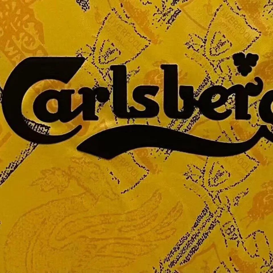 Liverpool retro bortatröja 1994/96, närbild på svart Carlsberg-tryck mot det gula mönstret