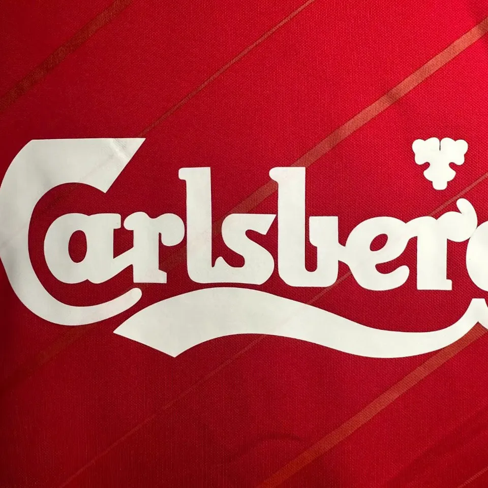 Liverpool retro hemmatröja 2005/06, närbild på vitt Carlsberg-tryck mot tonade diagonala ränder