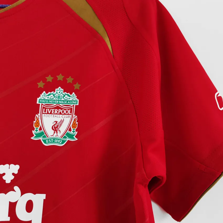 Liverpool retro hemmatröja 2005/06, vinklad bild på klubbmärke, guldfärgad axeldetalj och ärm