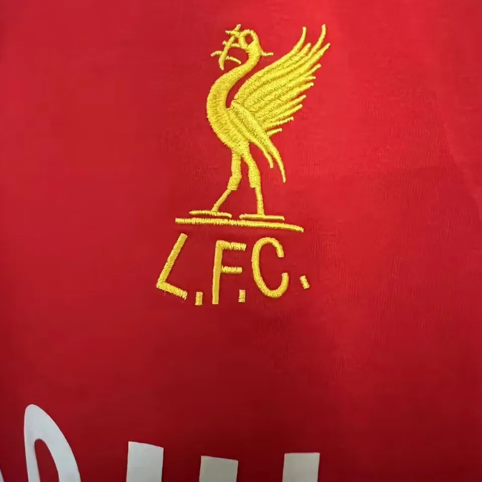 Liverpool retrotröja 1979, närbild på guldbroderad levfågel med texten L.F.C.