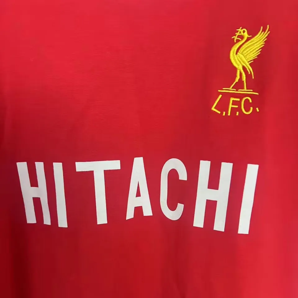 Liverpool retrotröja 1979, närbild på vitt Hitachi-tryck och broderad levfågel med L.F.C.